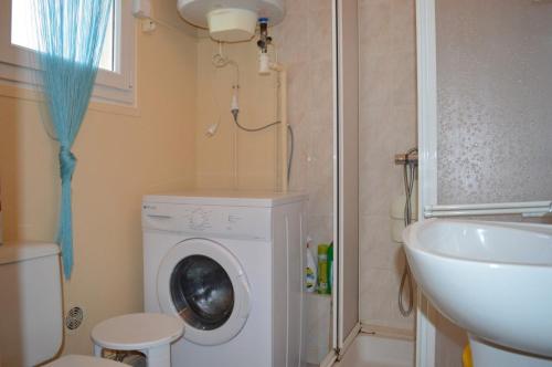 une salle de bain avec une machine à laver et un lavabo dans l'établissement Appartement studio 4 couchages SAINT CYPRIEN SC610-011, à Saint Cyprien Plage