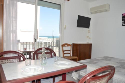 une salle à manger avec une table et des chaises et une grande fenêtre dans l'établissement Appartement studio 4 couchages SAINT CYPRIEN SC610-011, à Saint Cyprien Plage