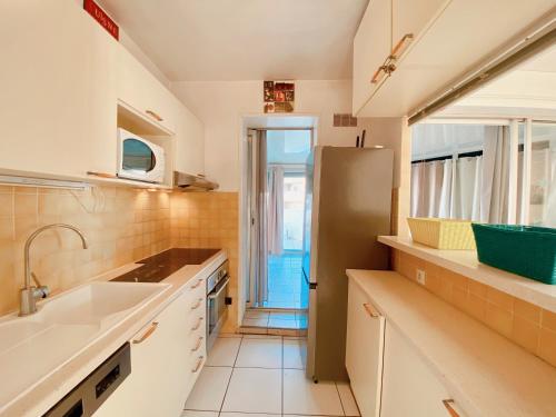 une cuisine avec un évier et un réfrigérateur dans l'établissement Appartement Terrasse vue Mer, à Canet