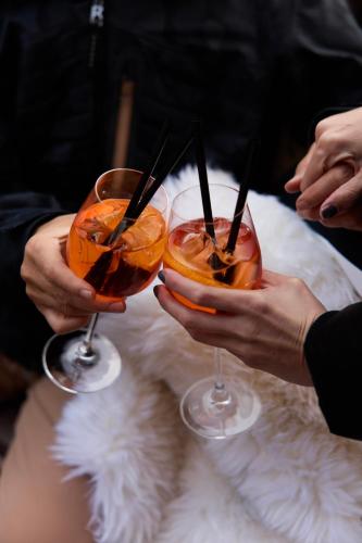 two people holding up two drinks in their hands at Swissôtel Resort Kolasin in Kolašin