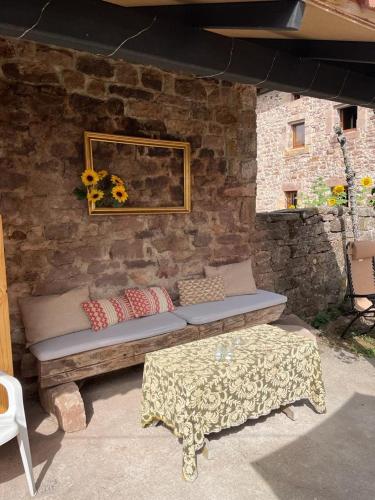 a stone wall with a bench and a table at El Rincón de Golobar en Brañosera in Brañosera