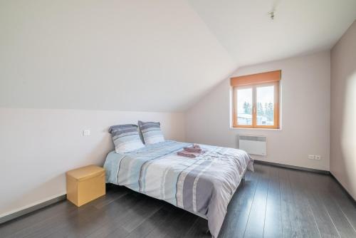 une chambre avec un lit et une fenêtre dans l'établissement La Perle Isolée - Grand appartement contemporain et chaleureux près de Pontarlier, à Doubs