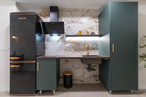 une cuisine avec un évier et un réfrigérateur dans l'établissement AG7 Loft Valencia Espaciosos estudios con terraza cercanos al metro Zona Ayora, à Valence