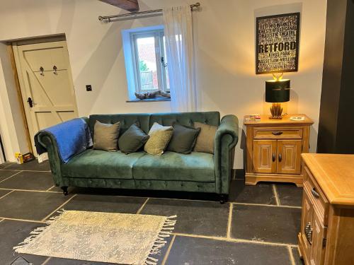 a living room with a green couch and a table at Torworth - 1 Bed Barn - Sleeps 3 - Hot Tub in Torworth