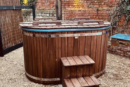 a wooden barrel with a bench next to a building at Torworth - 1 Bed Barn - Sleeps 3 - Hot Tub in Torworth