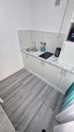a kitchen with a sink and a counter top at Marinad 1-ком Квартира в Центре города in Petropavlovsk