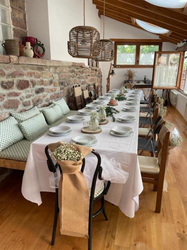 a long table in a room with a white table cloth at El Rincón de Golobar en Brañosera in Brañosera