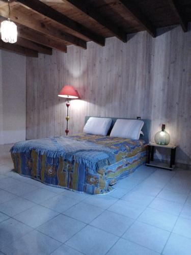 - une chambre avec un lit et une lampe dans l'établissement Maison en pierre pour 5, en pleine campagne, à Fleurac