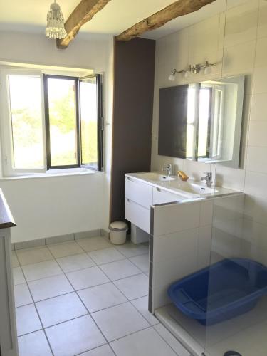 une salle de bain avec un lavabo et un miroir dans l'établissement Maison en pierre pour 5, en pleine campagne, à Fleurac