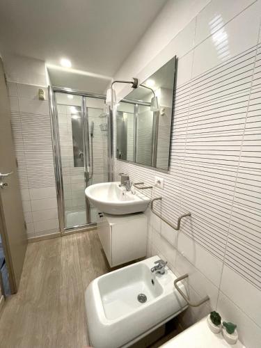 a white bathroom with a sink and a mirror at La Casetta in Grammichele