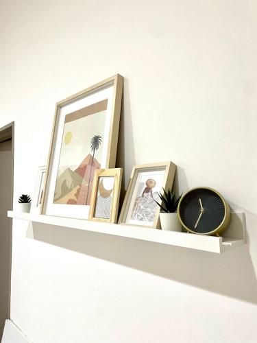 a shelf with pictures and a clock on a wall at La Casetta in Grammichele