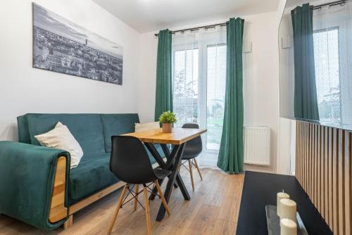 a living room with a green couch and a table at WrocApartments WestCenter - Parking Free in Wrocław