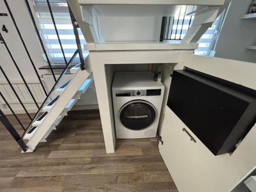a laundry room with a washer and dryer under a staircase at Moderne deluxe 3-Zi Eigentums- Maisonette-Wohnung IBM Bertrandt Mercedes in Ehningen