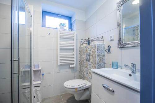 un bagno bianco con un water e un lavandino di Kékbazalt Vendégház a Badacsonytomaj