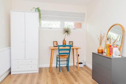 a dining room with a table and a blue chair at Modern 3-Bedroom 2-Bathroom Flat with Garden at Hanwell in Greenford