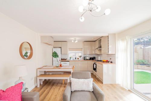 a kitchen and living room with a couch and a table at Modern 3-Bedroom 2-Bathroom Flat with Garden at Hanwell in Greenford