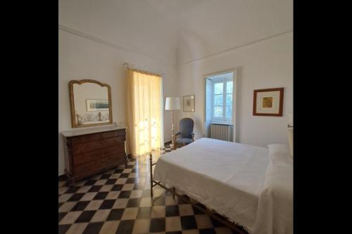 a bedroom with a bed and a mirror and a checkered floor at Villa Quartarella - La bellezza nel silenzio - piscina in Michelica