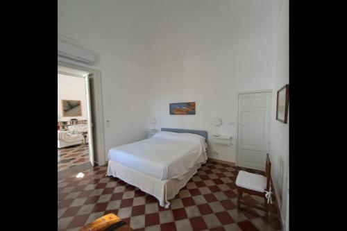 a bedroom with a white bed and a chair at Villa Quartarella - La bellezza nel silenzio - piscina in Michelica