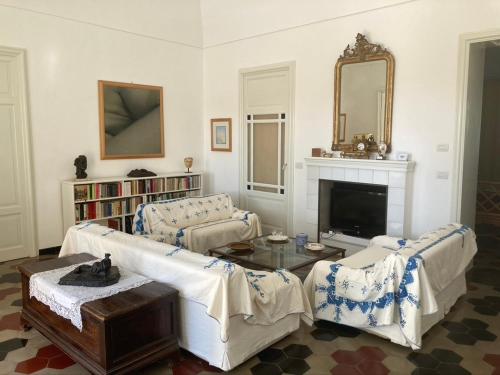 a living room with two couches and a fireplace at Villa Quartarella - La bellezza nel silenzio - piscina in Michelica