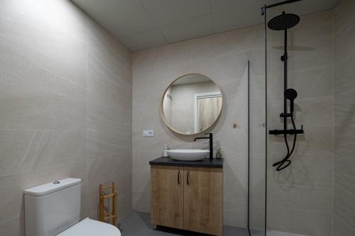 ein Badezimmer mit Toilette, Waschbecken und Spiegel in der Unterkunft ESC - Loft Valencia Cómodos y espaciosos estudios cercanos a estación Joaquín Sorolla in Valencia