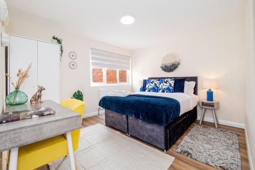a bedroom with a bed and a desk in it at Modern 3-Bedroom 2-Bathroom Flat with Garden at Hanwell in Greenford