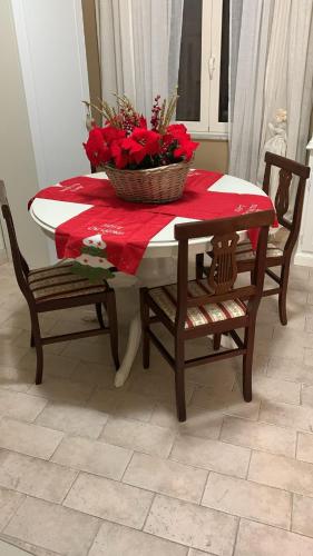 a table with a basket of red flowers on it at Casa Flea - Holiday apartment with 2 bedrooms in Gualdo Tadino