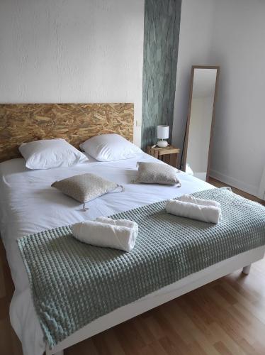 un grand lit blanc avec deux oreillers dessus dans l'établissement La Conquête, charmante maison de caractère, à Conques-sur-Orbiel