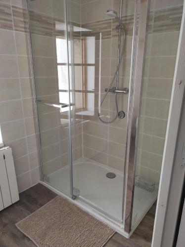 une douche avec une porte vitrée dans une salle de bain dans l'établissement La Conquête, charmante maison de caractère, à Conques-sur-Orbiel