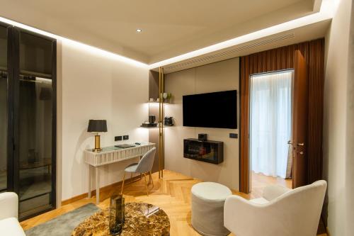a living room with a television and a room with a table at Hotel Delle Nazioni in Rome