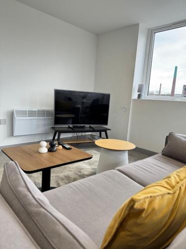 a living room with a couch and a flat screen tv at Two Bedroom Flat by Brookland Stays Serviced Accommodation Short Lets Leeds with Free WiFi in Yeadon