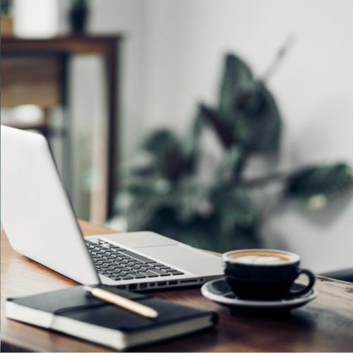 a laptop computer and a cup of coffee on a table at Hotel Ajax in Punta del Este