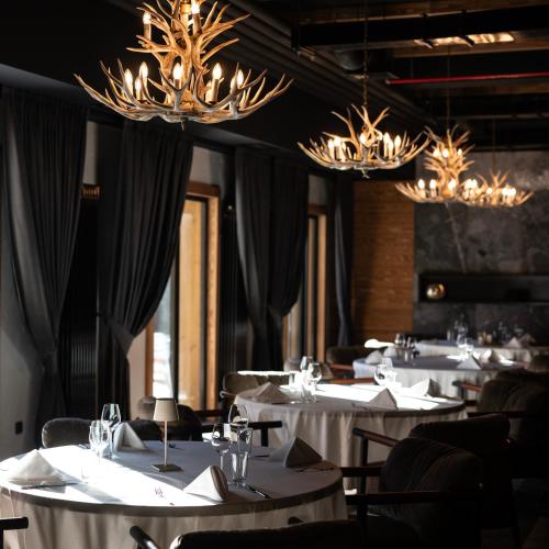 a dining room with white tables and chandeliers at Swissôtel Resort Kolasin in Kolašin