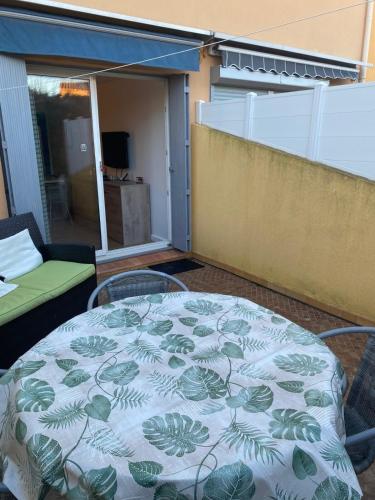 - une table sur un balcon avec une couverture dans l'établissement Studio terrasse proche plage, au Cap d'Agde