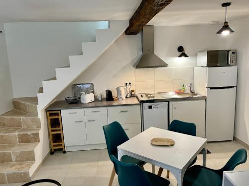 une cuisine avec une table et des chaises ainsi qu'un escalier dans l'établissement 2 suites, cour privée, climatisation, Le nid de Blois Vienne, à Blois