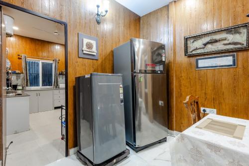 a large refrigerator in a kitchen with wooden walls at Summit View 3bhk by Roamhome in Bhikia Sain