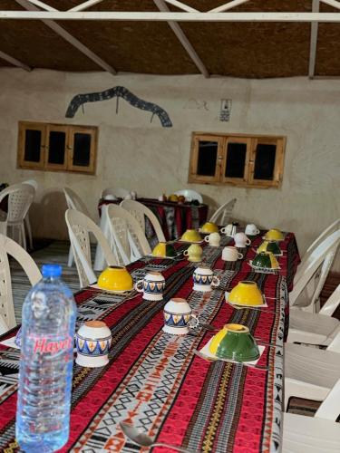 a long table with a bottle of water on it at Camp Dunes Insolites Sabria in Sabria