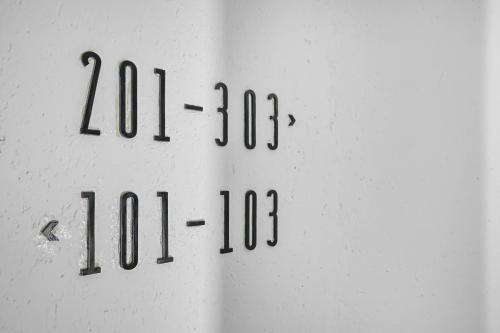 a white wall with black numbers on it at JIJI Suites in Combs-la-Ville