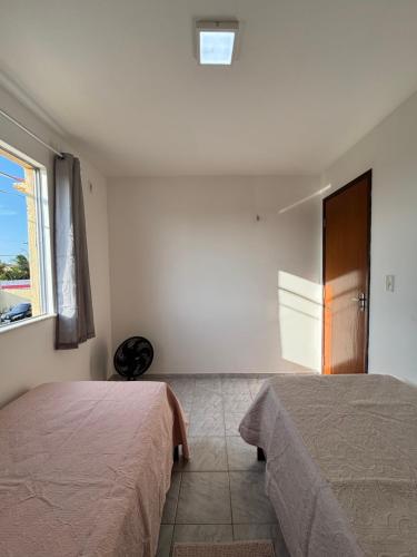 una camera da letto con due letti e una finestra di Super ventilado próximo do Aeroporto e da UEMA a São Luís