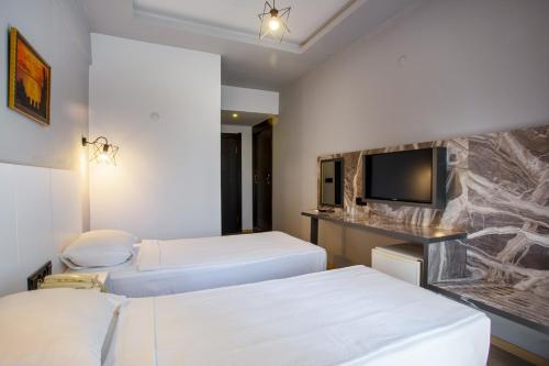 Postel nebo postele na pokoji v ubytování Aslan Sand & City Hotel