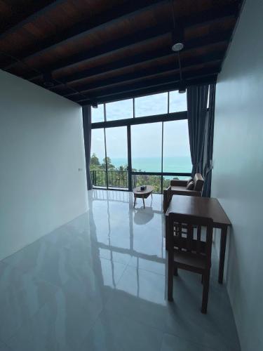a room with a table and a chair and a window at Scenery Sunrise in Chaweng Noi Beach