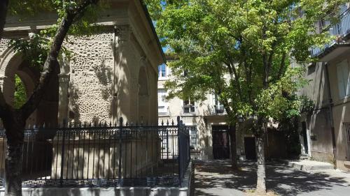 a gate in front of a building with trees at Chambre de charme au coeur du vieux Valence - Confort & Calme in Valence