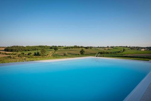 a large swimming pool with a view of a field at Borgo Syrah in Cortona