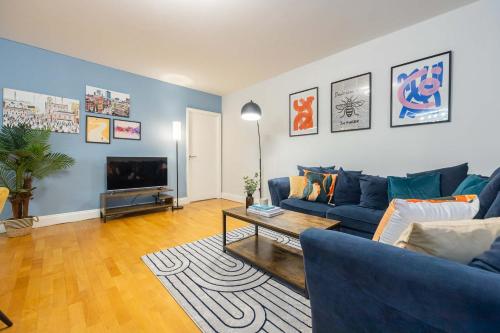 a living room with a blue couch and a tv at Canal Street Apartment in Manchester