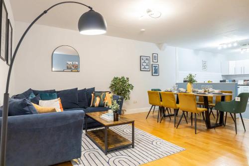 a living room with a blue couch and a table at Canal Street Apartment in Manchester