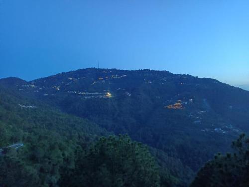 a view of a mountain with houses on it at The Mesmerizing Villa I Kufri I Nature Walk I Family Events & Bonfire I Memories & Enjoyment Villa I Operated by Exotic Stays in Kūfrī