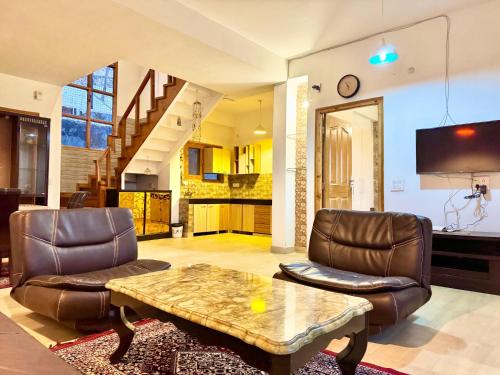 a living room with two chairs and a coffee table at The Mesmerizing Villa I Kufri I Nature Walk I Family Events & Bonfire I Memories & Enjoyment Villa I Operated by Exotic Stays in Kūfrī