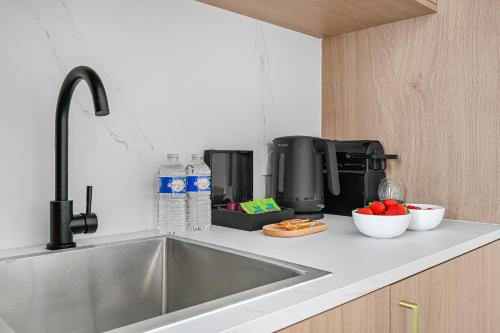 a kitchen counter with a sink and a coffee maker at JIJI Suites in Combs-la-Ville