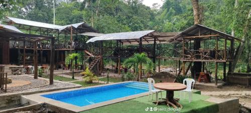 a resort with a swimming pool and a house at Casa Rosalía in Sucúa