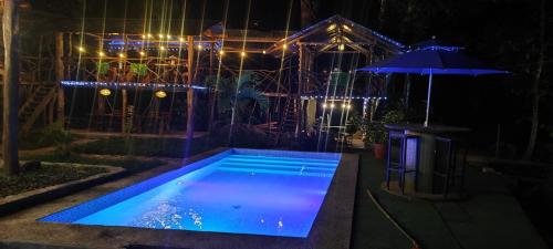 a swimming pool at night with an umbrella at Casa Rosalía in Sucúa