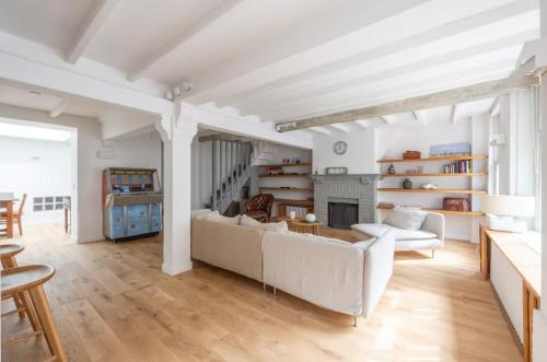 un salon avec un canapé blanc et une cheminée dans l'établissement Belle maison de pêcheurs Normande refaite par un architecte, à Trouville-sur-Mer
